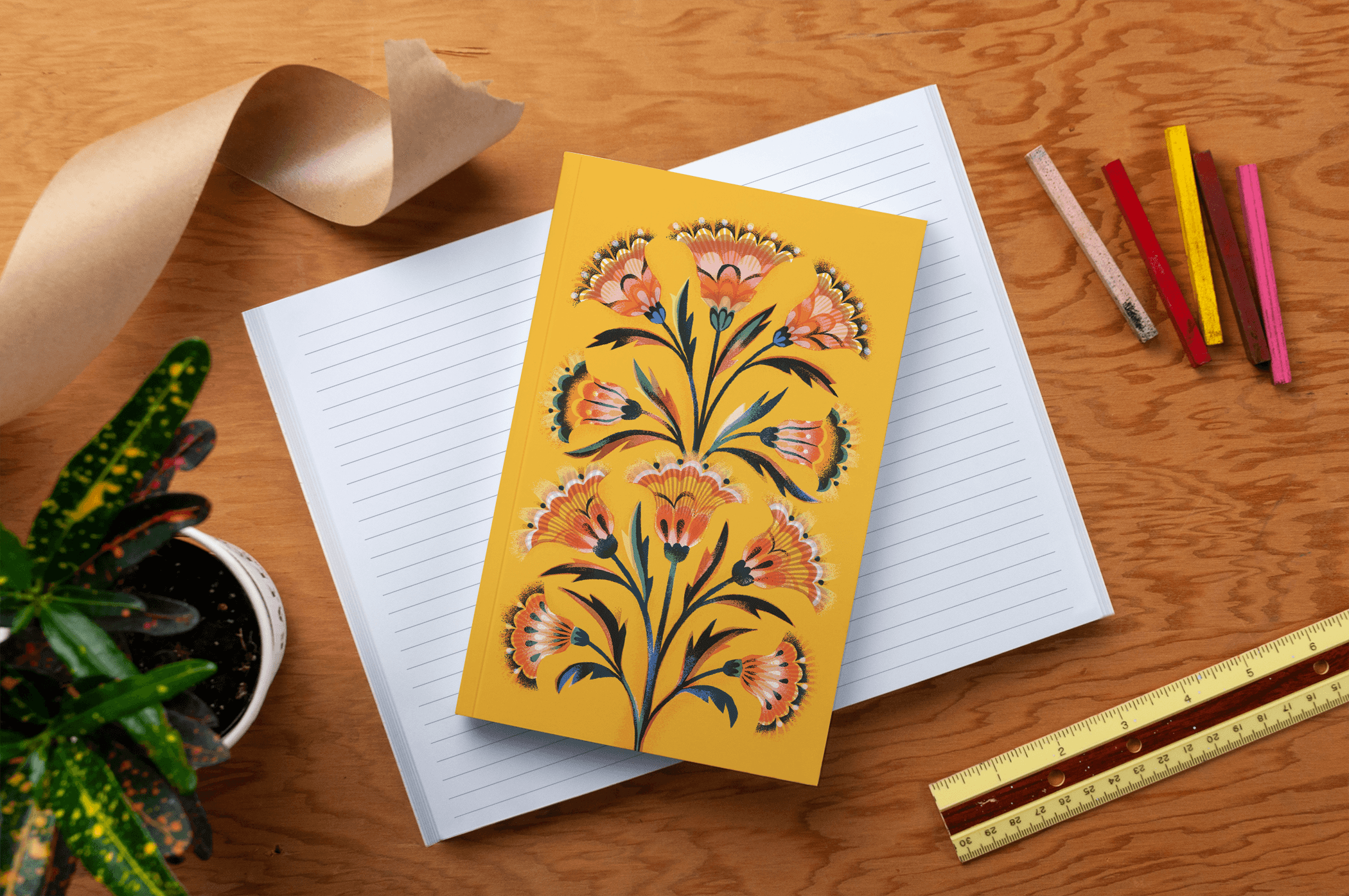 A yellow notebook journal with a symmetrical floral design