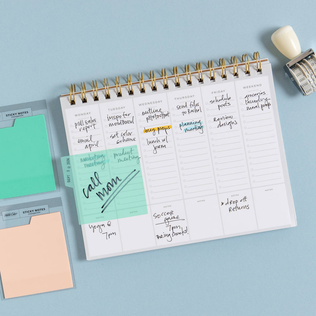 Planner with sticky notes and a stamp on a light blue background