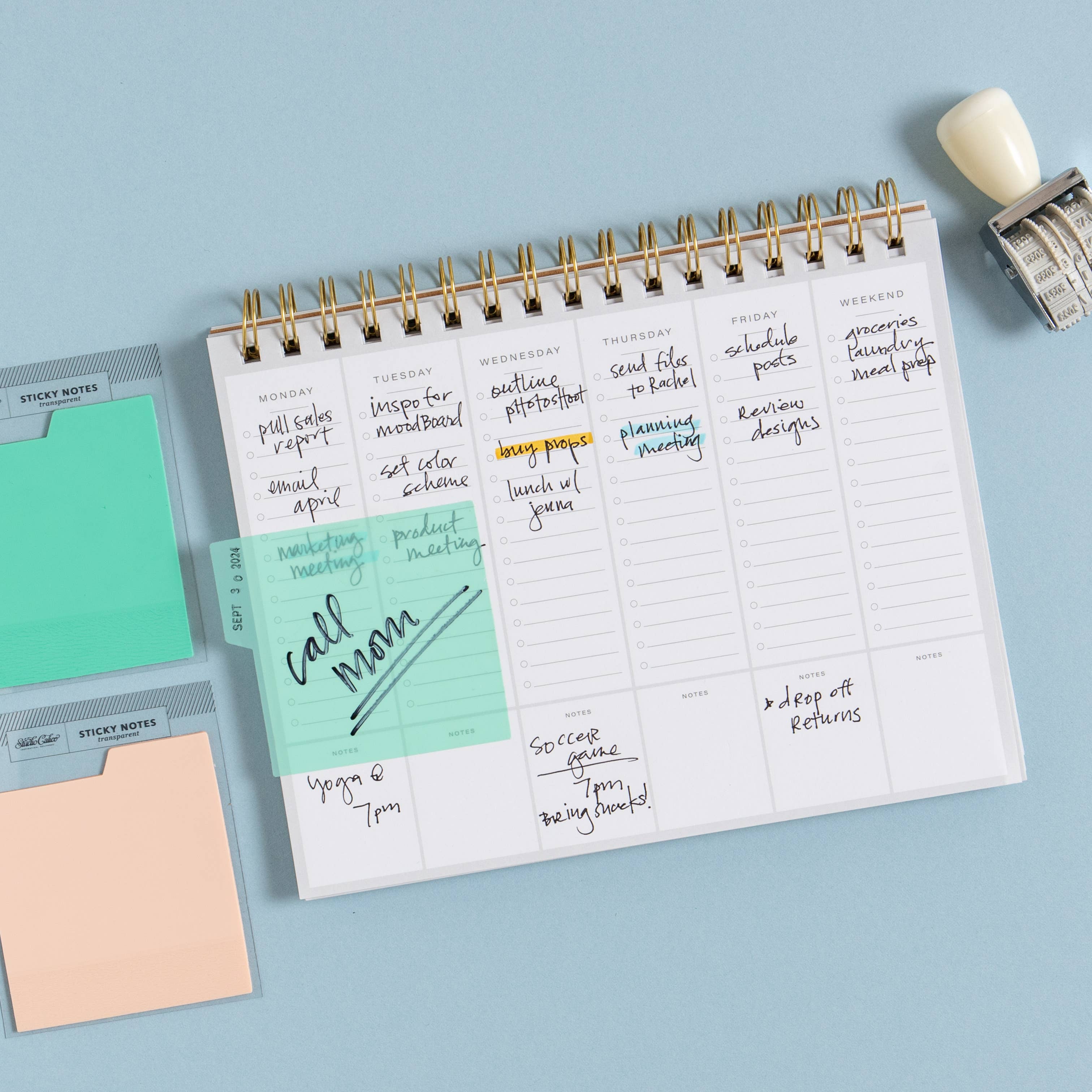 Planner with sticky notes and a stamp on a light blue background