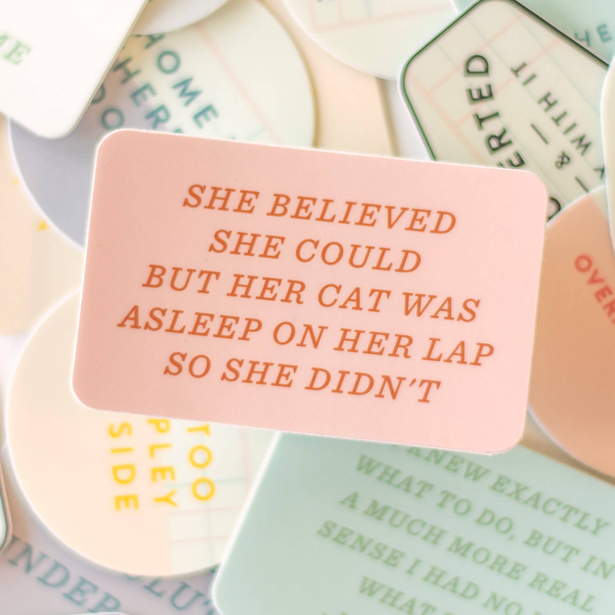 Motivational card with text 'She believed she could but her cat was asleep on her lap so she didn't' surrounded by other cards.