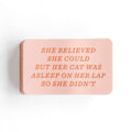 Pink sticker with the text "she believed she could but her cat was asleep on her lap so she didn't"