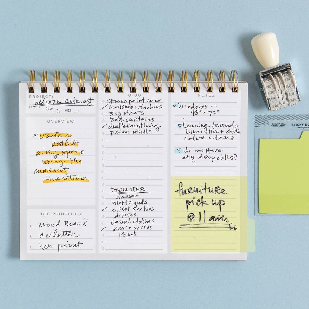 Notebook with handwritten to-do list and sticky notes on a light blue background